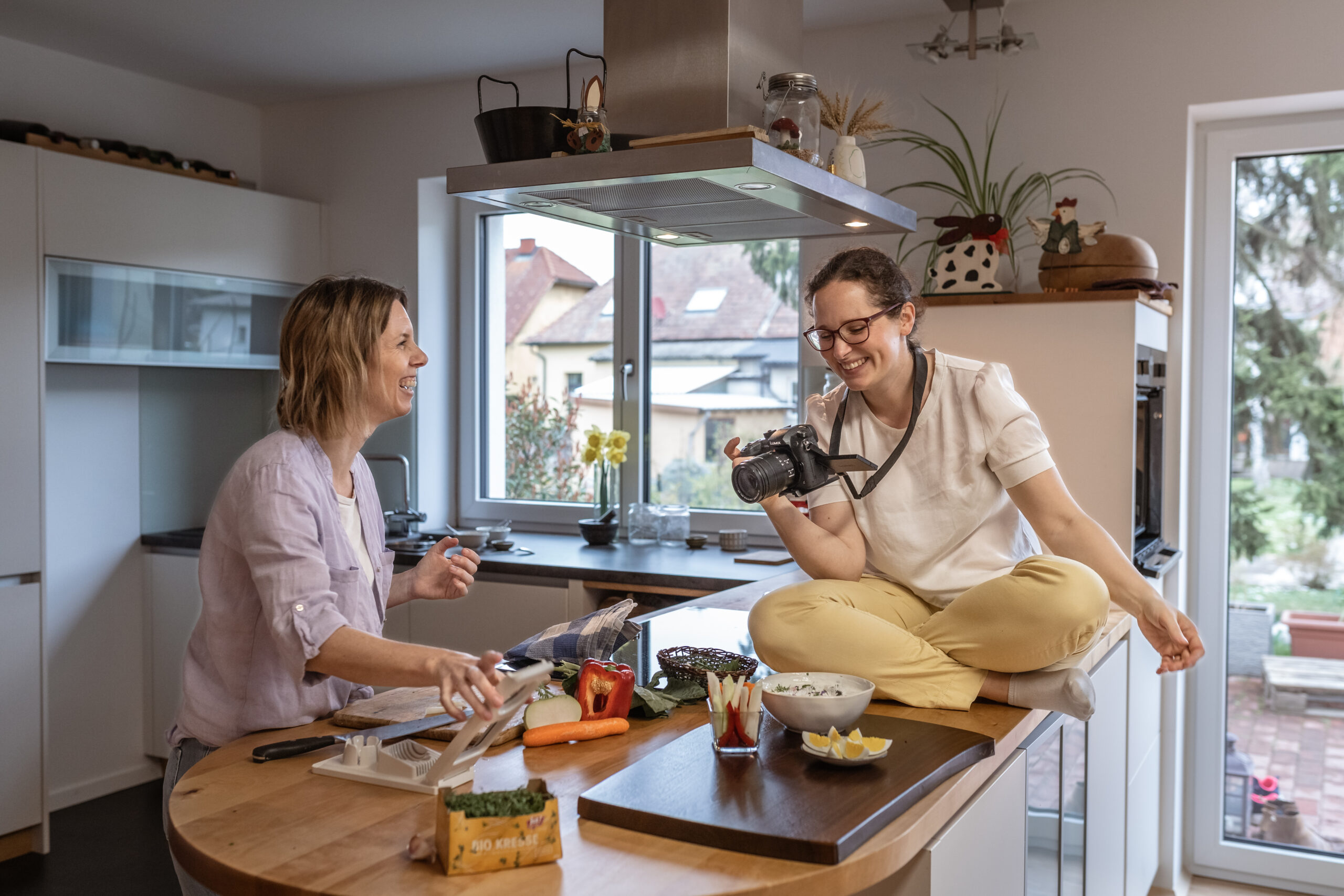 Agnes Rehor filmt eine Diätologin beim Kochen. Beide lachen.