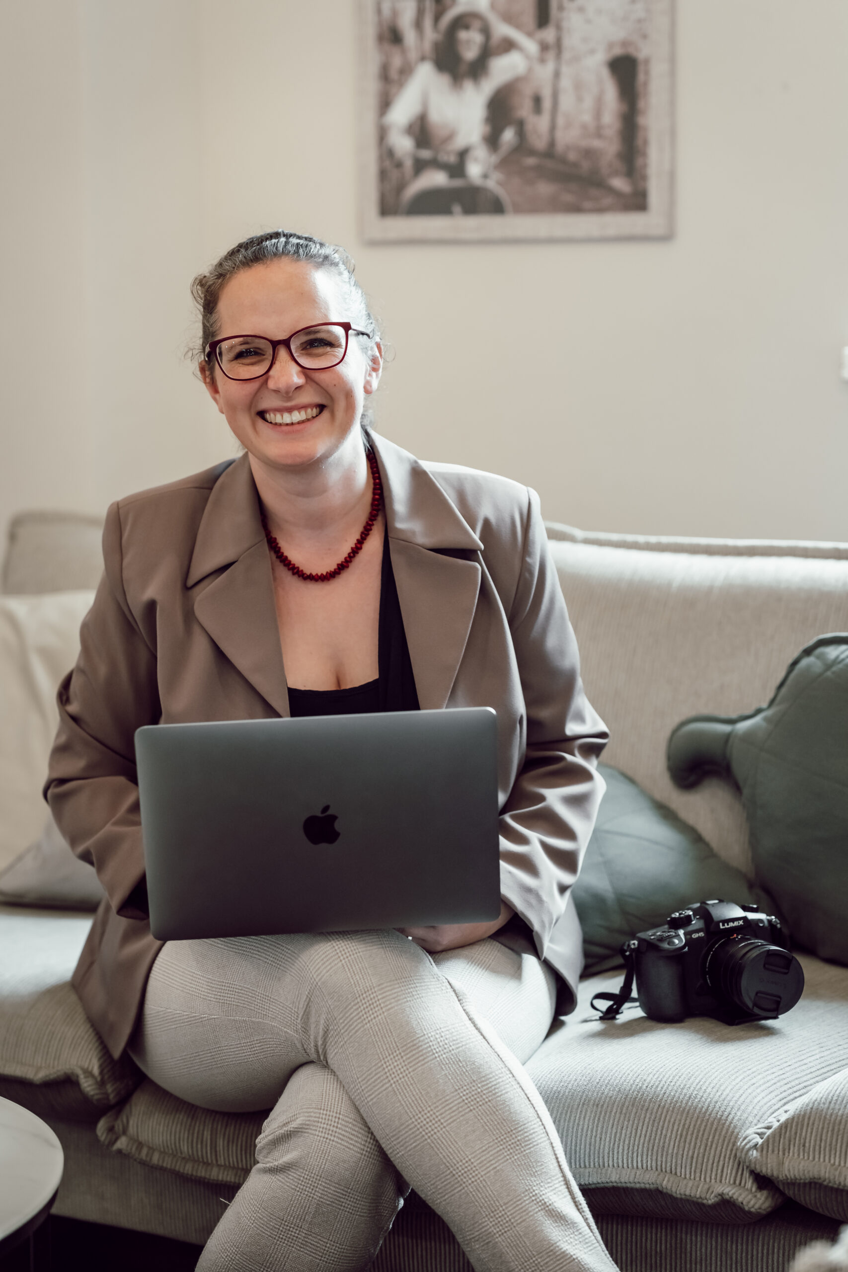 Agnes Rehor sitzt am Laptop und lacht in die Kamera